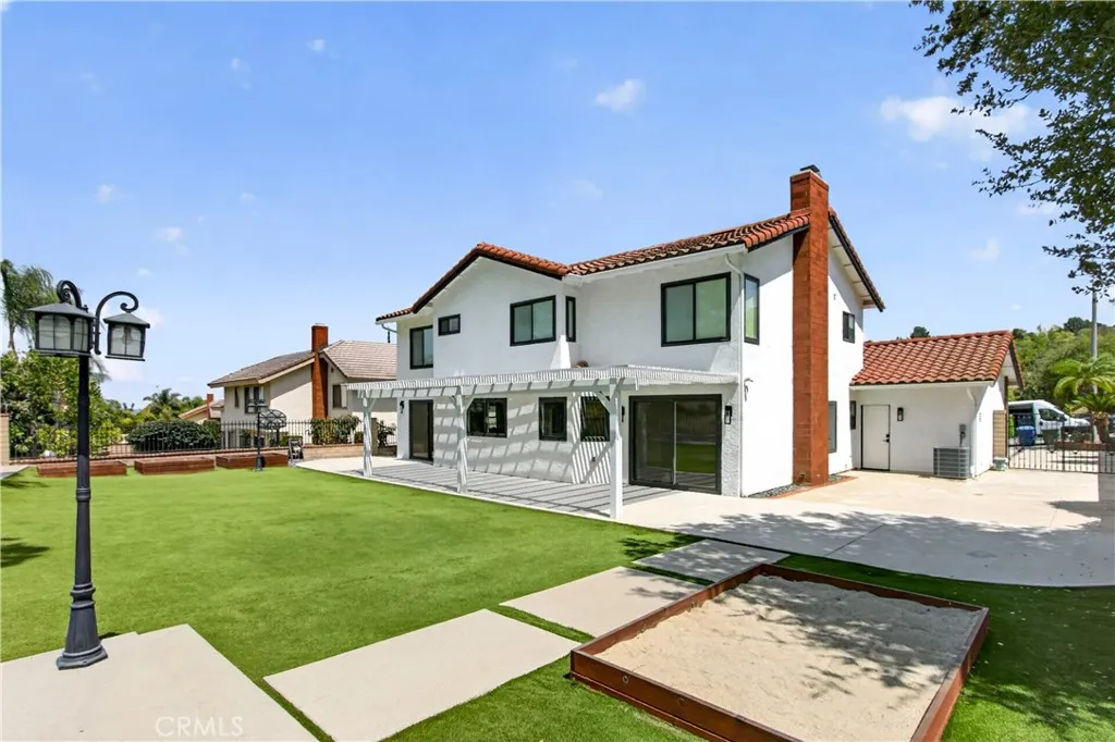 Spacious backyard featuring a dedicated sandbox area, perfect for the little ones