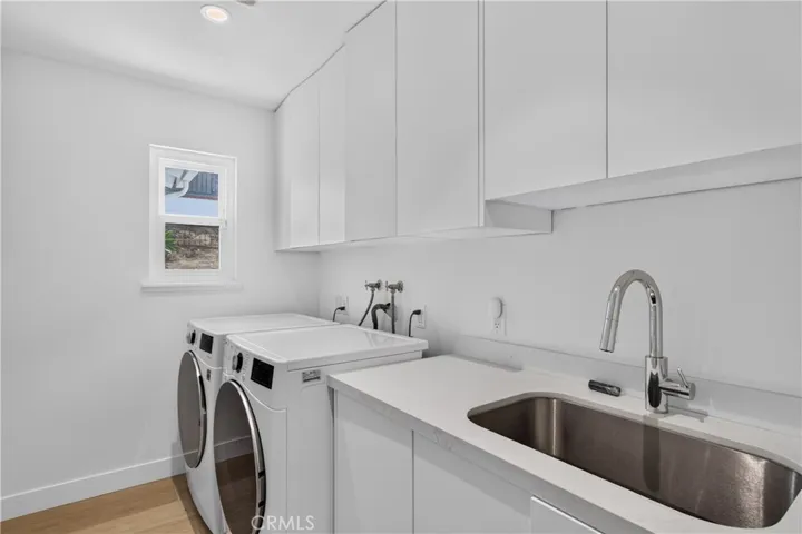 Laundry room with sink and plenty of storage space