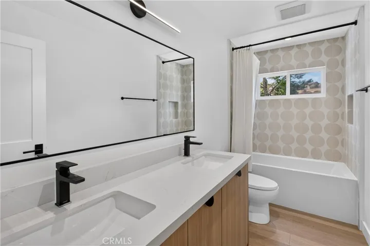 Hallway bathroom featuring a dual vanity, a soaking tub, and shower.