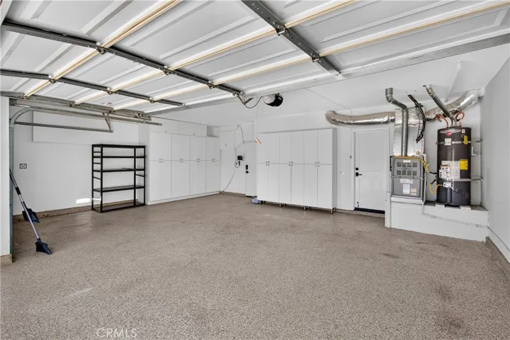 Attached 3-car garage with durable epoxy flooring and custom built-in cabinetry for organized storage.