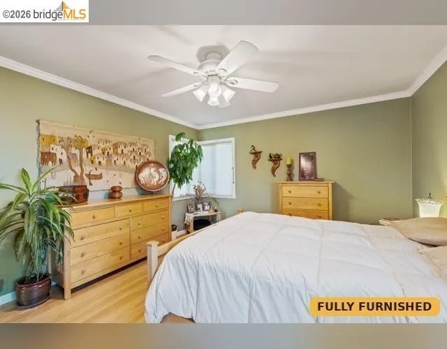 Spacious bedroom on northeasterly corner of the home. Queen bed Hardwood flooring, crown molding, ceiling fan with integrated lighting, and windows with blinds