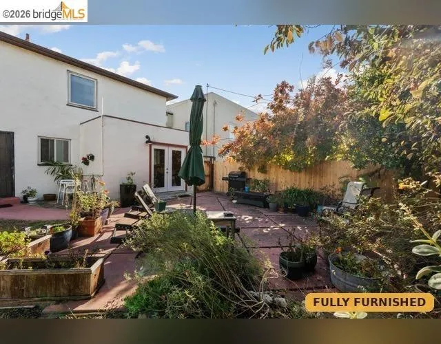 Backyard patio featuring hardscaping, privacy fencing, and established perimeter plantings