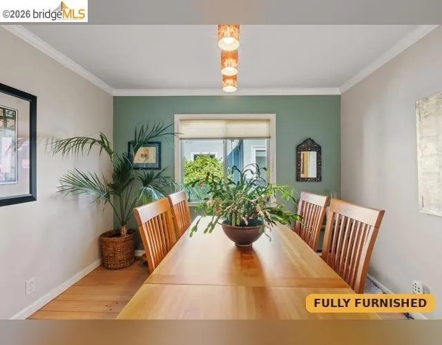 Wood-finish flooring, crown molding, and a windows with blinds thorughout.