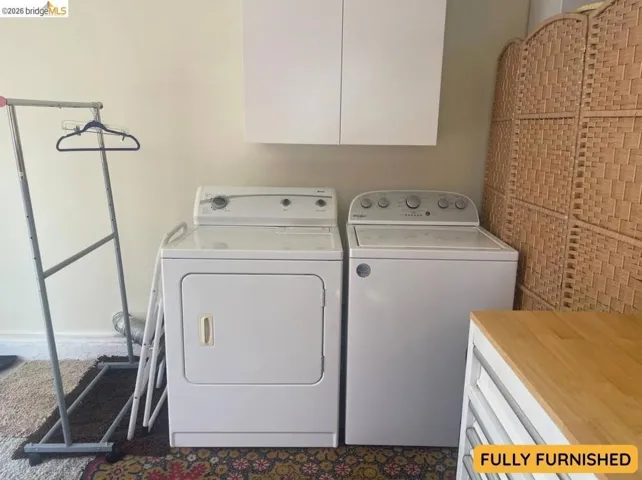 Washer and dryer appliances with overhead white cabinetry
