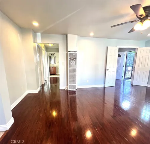 Living room. On the left is the bathroom and entrances to bedrooms 1 & 2. On the right are the doors leading to bedroom #3 and the back patio.