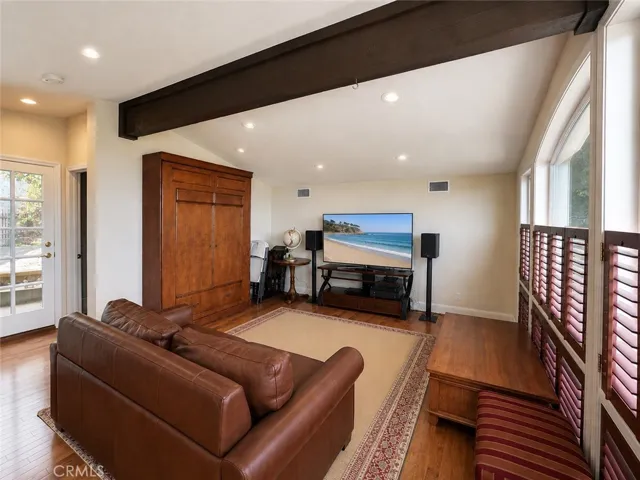 A multipurpose room with ocean views, a sofa, bed, and Murphy bed.