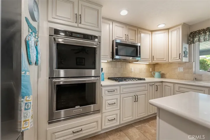 Top-of-the-line appliances include dual oven, stainless steel microwave, and stove top