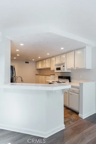 Open kitchen with breakfast bar overlooking the main living area.