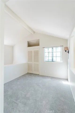 Versatile loft area featuring vaulted ceilings, natural light, and closet storage.