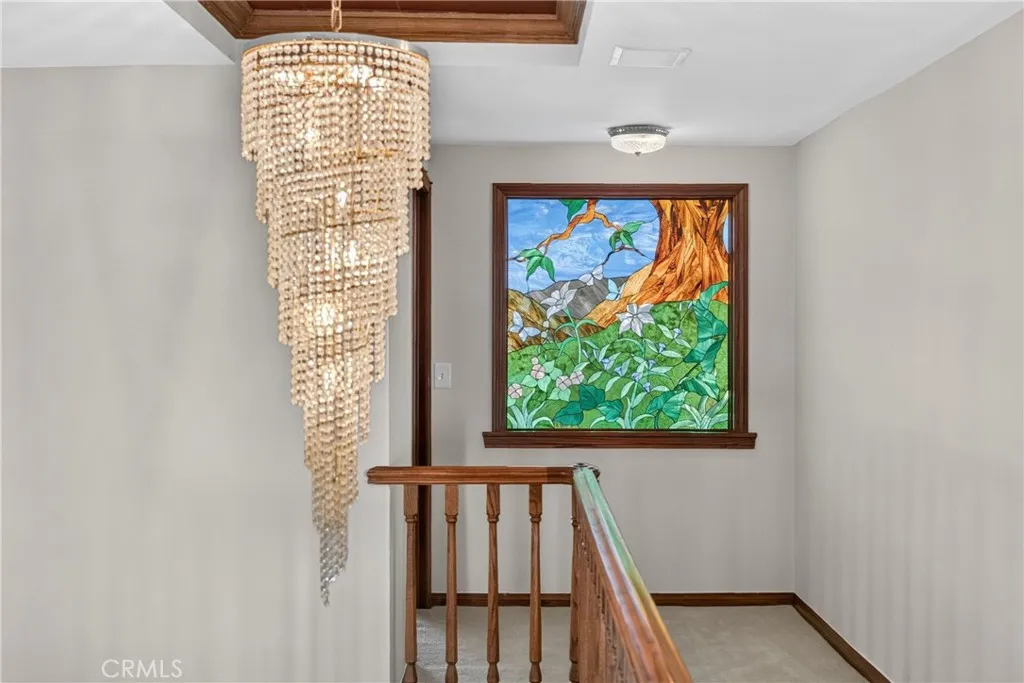 Spiral Teardrop Crystal Chandelier and stained glass window on upper floor