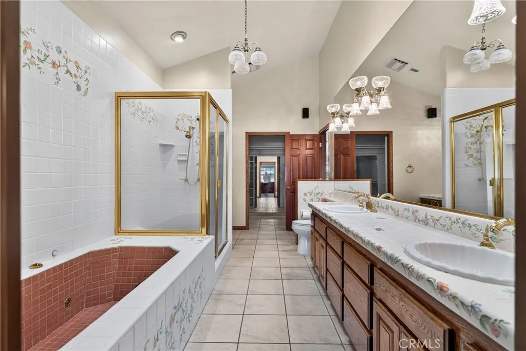 Primary Ensuite Bathroom with dual sinks, vanity area, soaking tub, shower, walk in closet