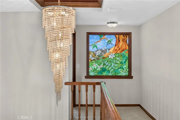 Spiral Teardrop Crystal Chandelier and stained glass window on upper floor