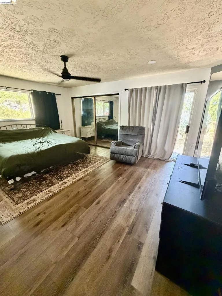 Wood-finish flooring throughout, featuring a ceiling fan and recessed lighting