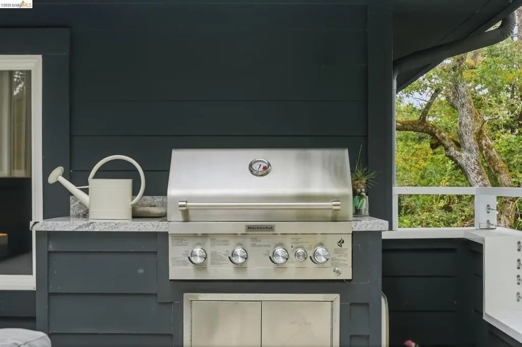 Built-in stainless steel grill set within a dark-painted outdoor kitchen cabinet Built-in stainless steel grill set within a dark-painted outdoor kitchen cabinet