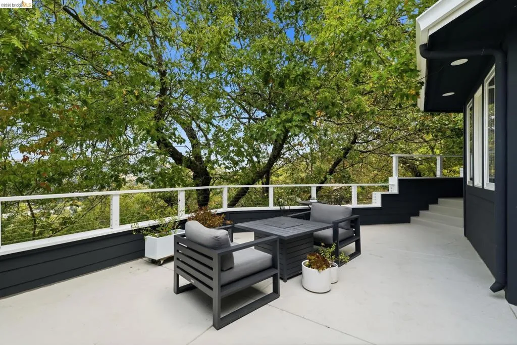 Expansive outdoor deck with a white railing system, dark exterior siding, white trim, and a built-in staircase Expansive outdoor deck with a white railing system, dark exterior siding, white trim, and a built-in staircase