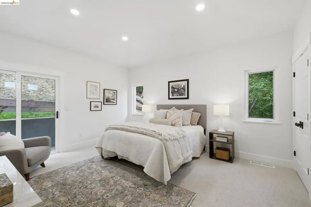 Recessed lighting, white walls, light-colored carpeting, sliding glass door, and a paneled interior door Recessed lighting, white walls, light-colored carpeting, sliding glass door, and a paneled interior door