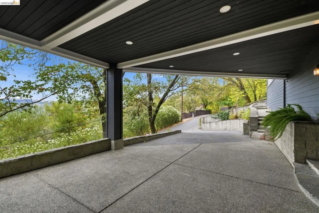 Covered carport featuring an exposed aggregate concrete surface, recessed lighting, and a slatted ceiling Covered carport featuring an exposed aggregate concrete surface, recessed lighting, and a slatted ceiling