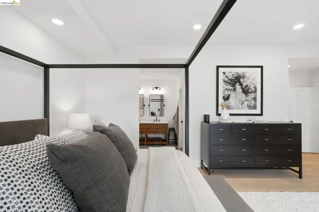 Recessed lighting, wood-finish flooring, and a contemporary black dresser Recessed lighting, wood-finish flooring, and a contemporary black dresser