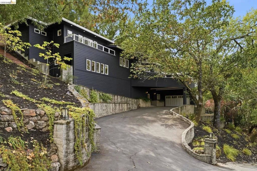 Multi-level residence featuring dark siding and white-framed windows Multi-level residence featuring dark siding and white-framed windows