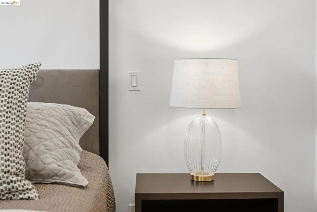 Built-in headboard, dark wood-finish nightstand, and light switch Built-in headboard, dark wood-finish nightstand, and light switch