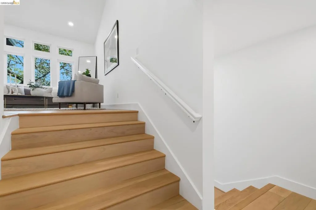 Light wood flooring on stairs, white walls, multiple windows, recessed lighting Light wood flooring on stairs, white walls, multiple windows, recessed lighting