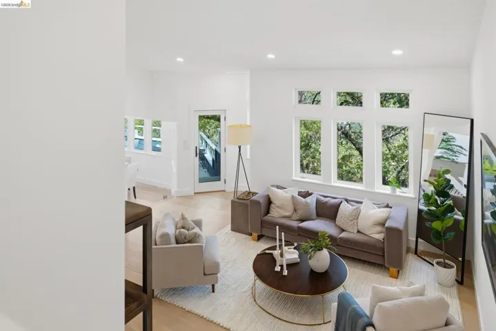 Bright living space with wood-finish flooring, recessed lighting, and multiple windows