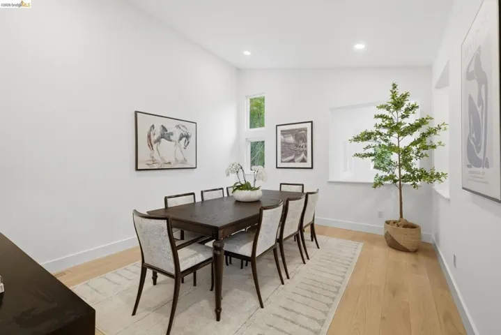 Light wood-finish flooring, recessed lighting, and high ceilings