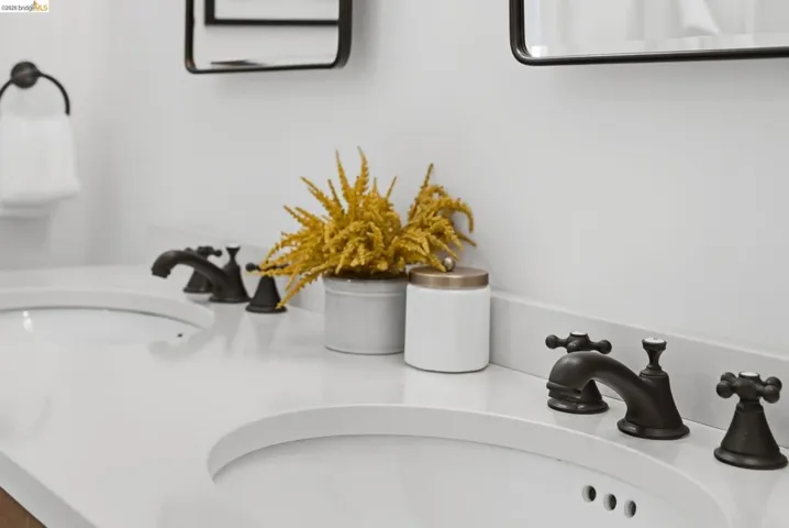 Dual integrated sinks with white countertops and oil-rubbed bronze fixtures