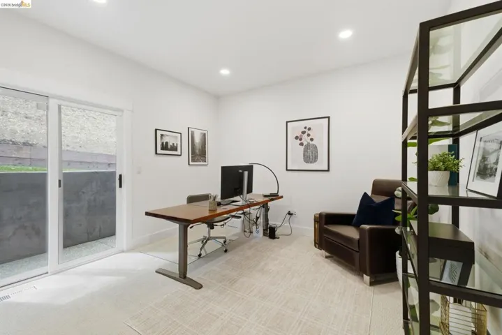 Recessed lighting, light-toned carpeting, white walls, and a sliding glass door