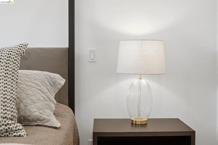 Built-in headboard, dark wood-finish nightstand, and light switch