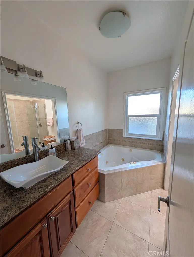 Sspacioua primary bathroom featuring a soaking tub, separate shower and abundant natural light.