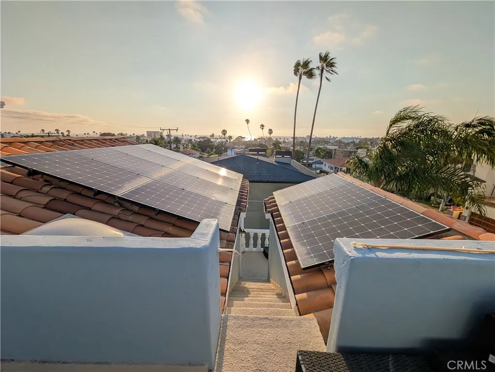 Expansive rooftop deck offering panoramic coastal, neighborhood and palm-tree views. Solar Panels included in sale.