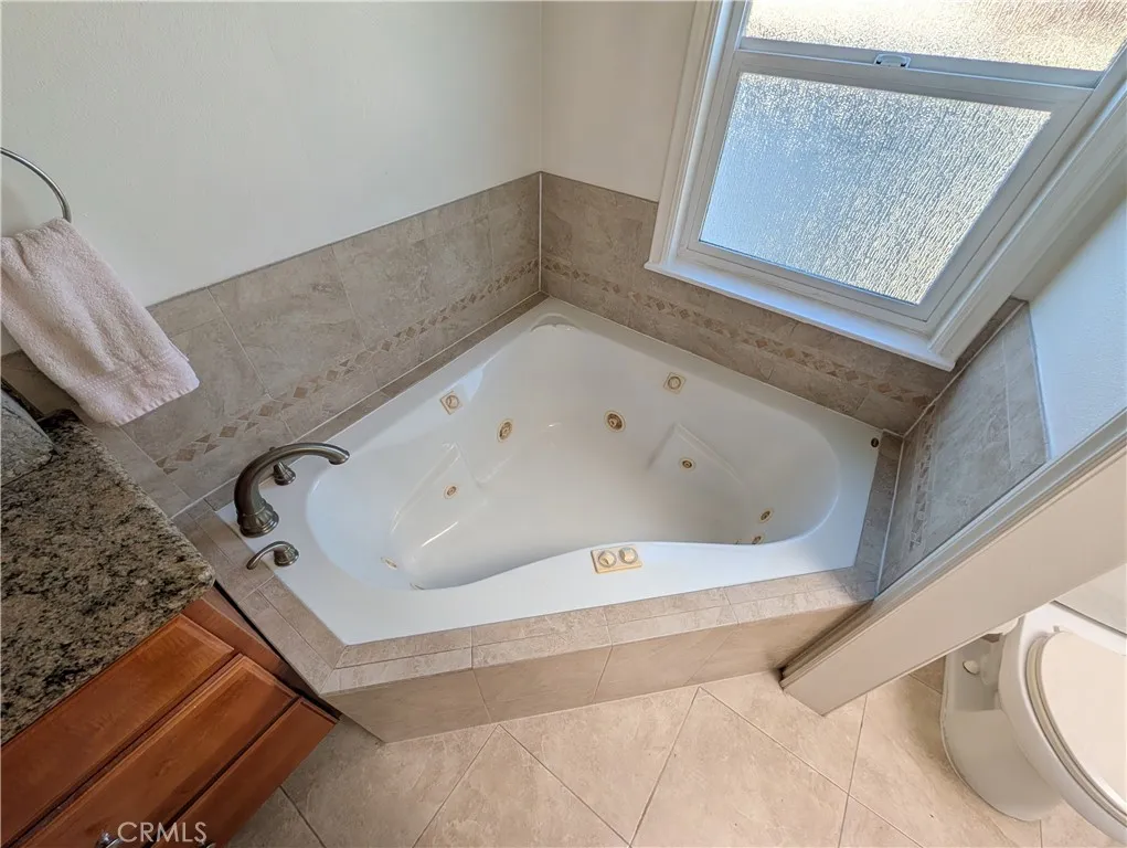 Relaxing soaking tub positioned beneath a window, creating a peaceful spa-like retreat.