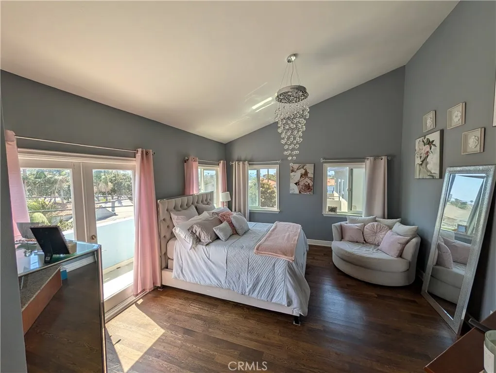 Private primary suite retreat featuring hardwood floors, relaxed sitting area and direct balcony access.
