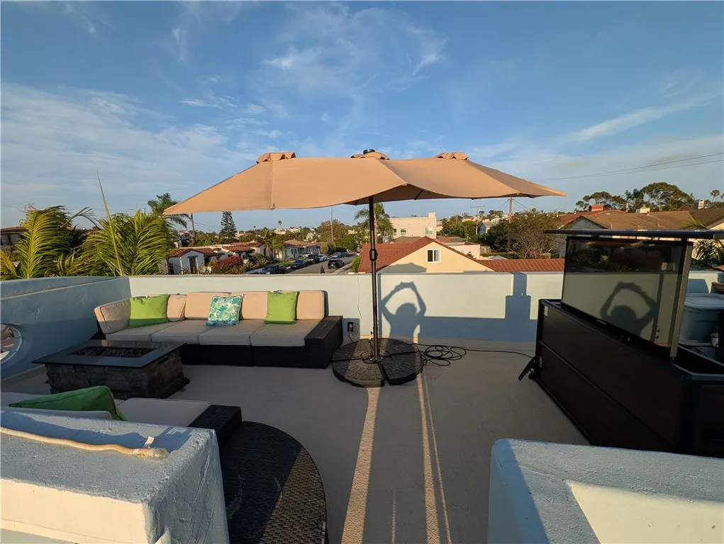 Wide rooftop-deck view showcasing multiple seating areas and abundant entertaining space.
