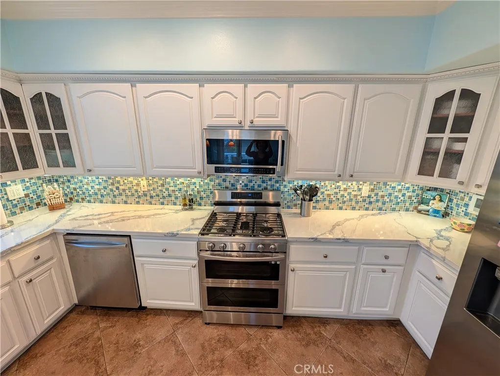 Kitchen showcasing abundant cabinetry, stainless steel appliances.