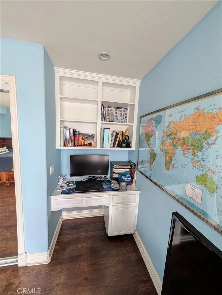 Built in desk and cabinetry create a convenient workspace or study area within the bedroom.