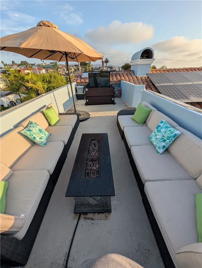 Rooftop entertaining area featuring comfortable seating and a dramatic fire feature.