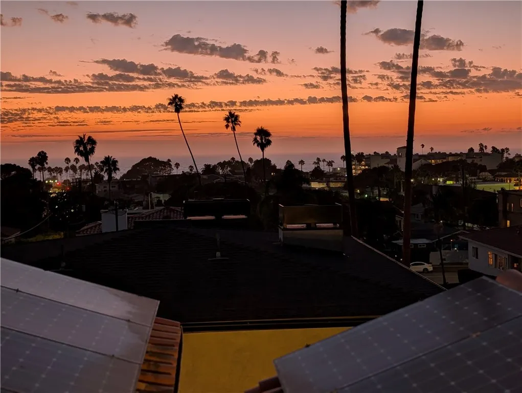 Spectacular sunset view from the rooftop deck, showcasing vivid coastal skies and iconic palm-tree silhouettes.