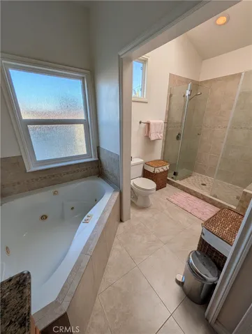 Bright vanity area with generous counter space, warm wood cabinetry and a large mirror.