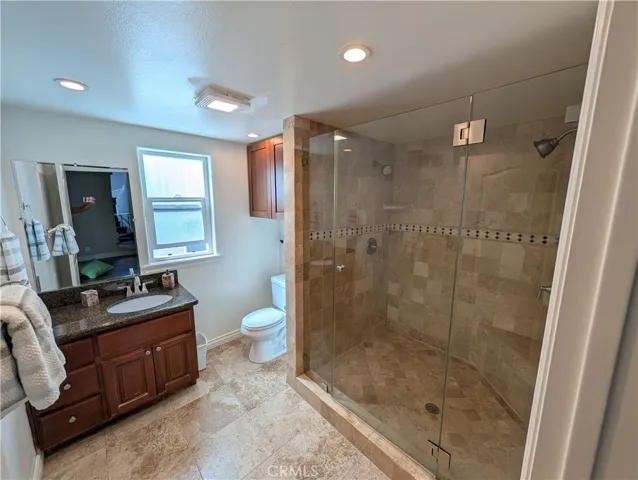 Second level shared bathroom featuring a glass enclosed shower with dual shower heads on opposite sides, attractive tilework and stylish vanity.