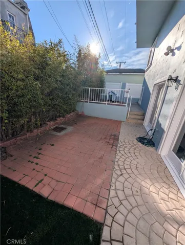 Secluded rear patio surrounded by mature greenery ideal for outdoor dining and gatherings.