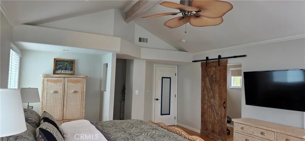 Primary Suite with Vaulted Ceiling and Large Smart TV, Opens to Separate Office behind barn door