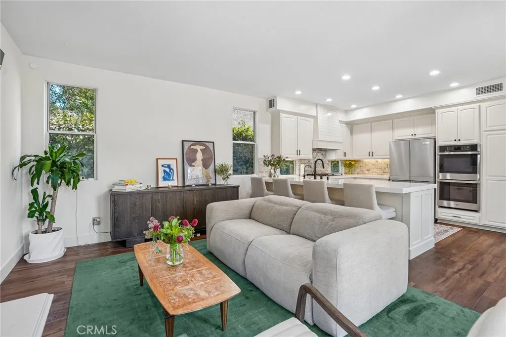 Elegant family room adjoining the kitchen, anchored by a beautiful fireplace.