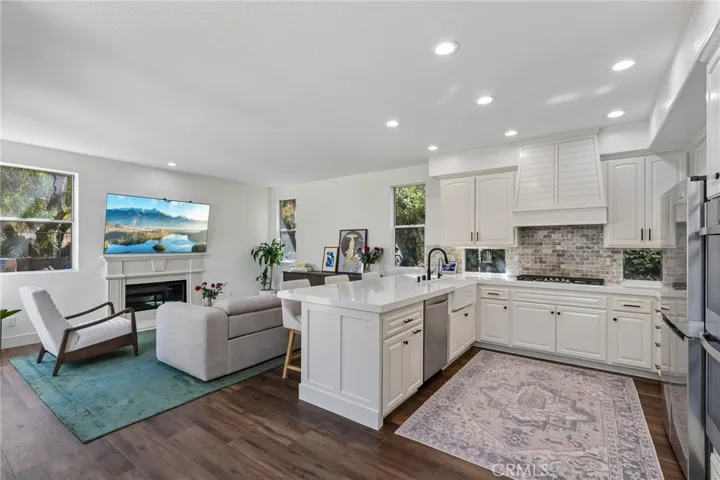 Elegant family room adjoining the kitchen, anchored by a beautiful fireplace.