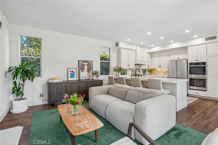 Elegant family room adjoining the kitchen, anchored by a beautiful fireplace.