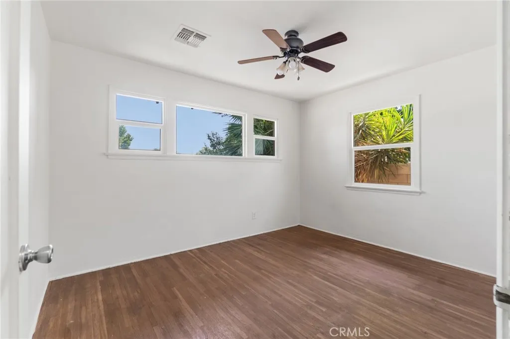 Second bedroom with wood floors and ceiling fan