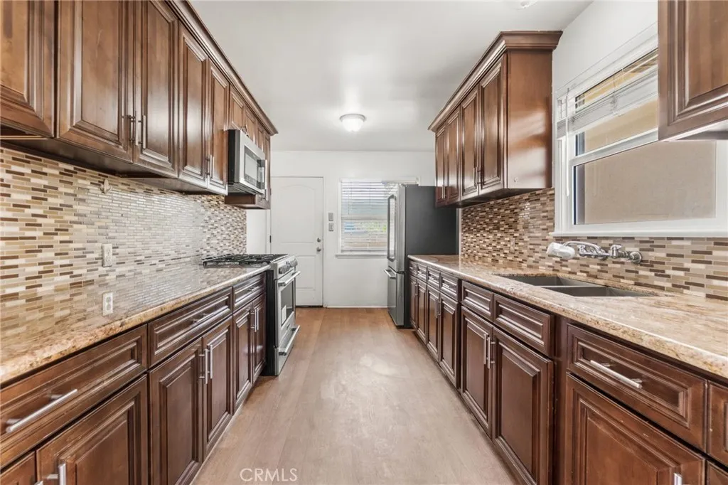 Kitchen with stainless gas range and over the range microwave
