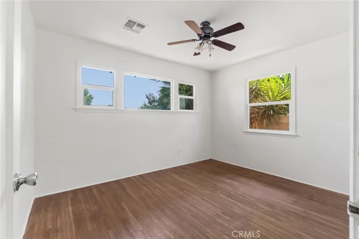 Second bedroom with wood floors and ceiling fan