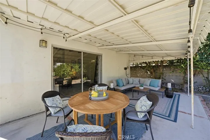 Covered porch in backyard with access to house via sliding door into the family room or utility door into the kitchen